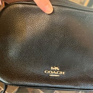 Black coach purse with adjustable strap.